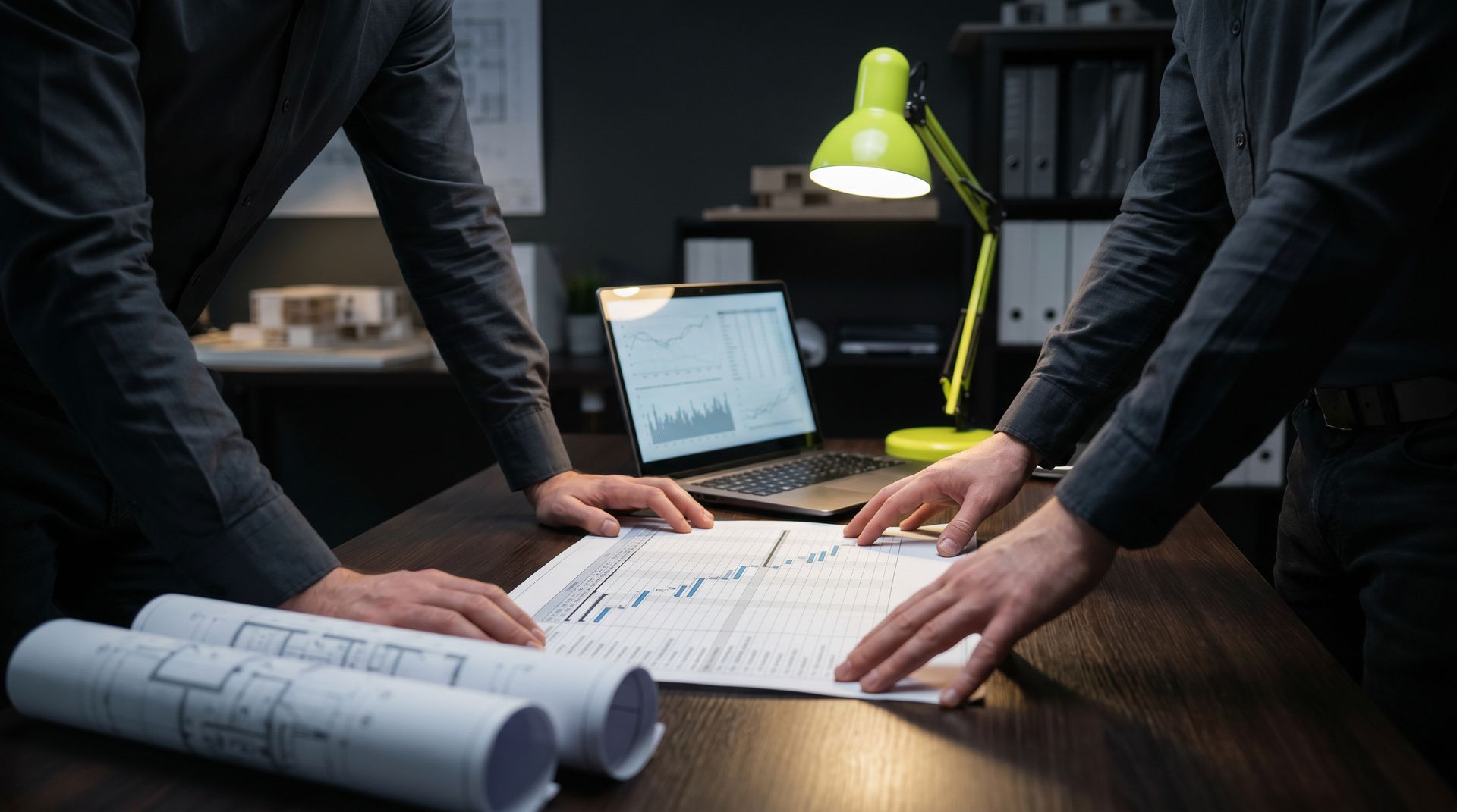 Engineers reviewing a project schedule and cost forecast on a desk